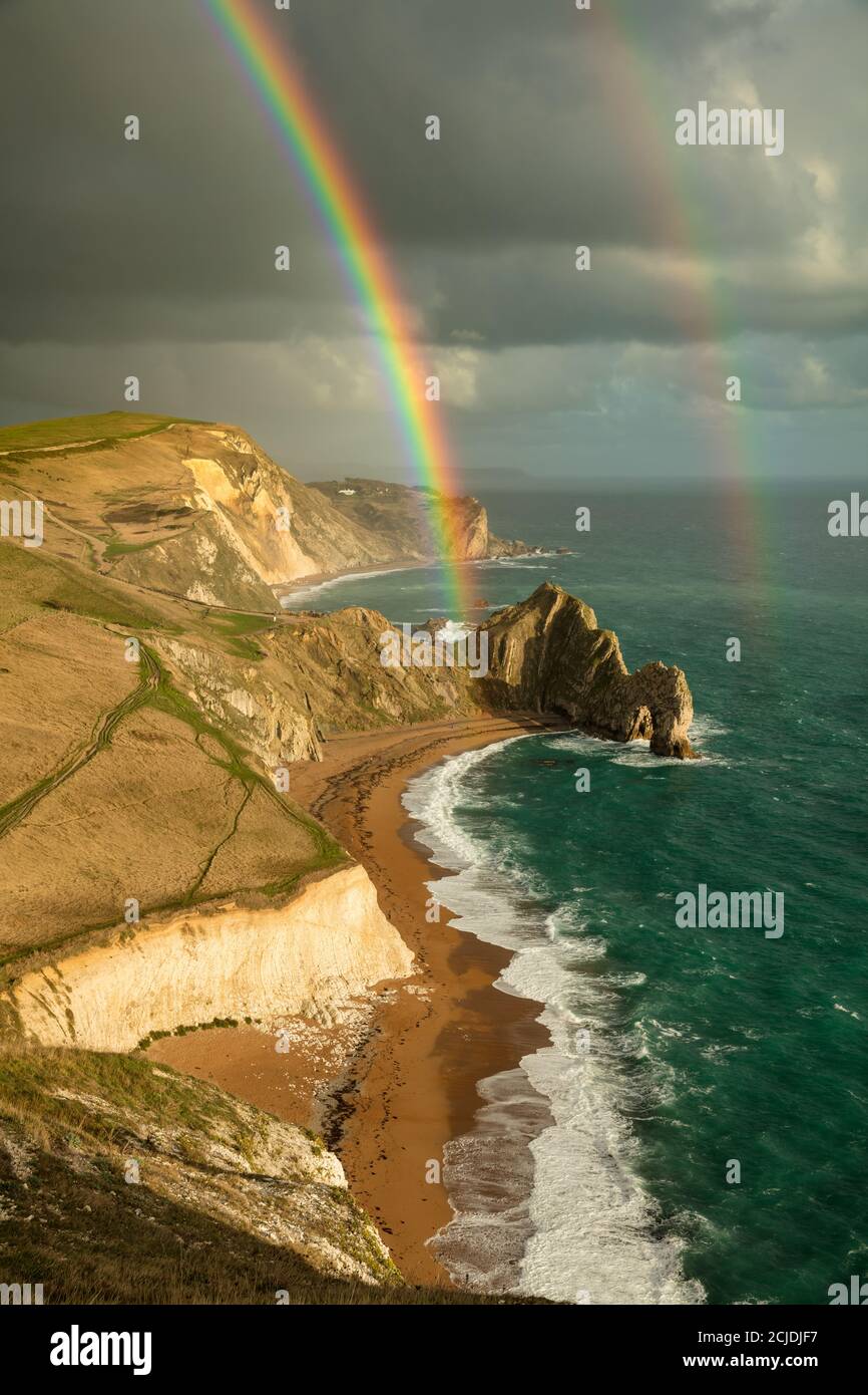 Ein Regenbogen über Durdle Door und der Jurassic Coast, Dorset, England, Großbritannien Stockfoto