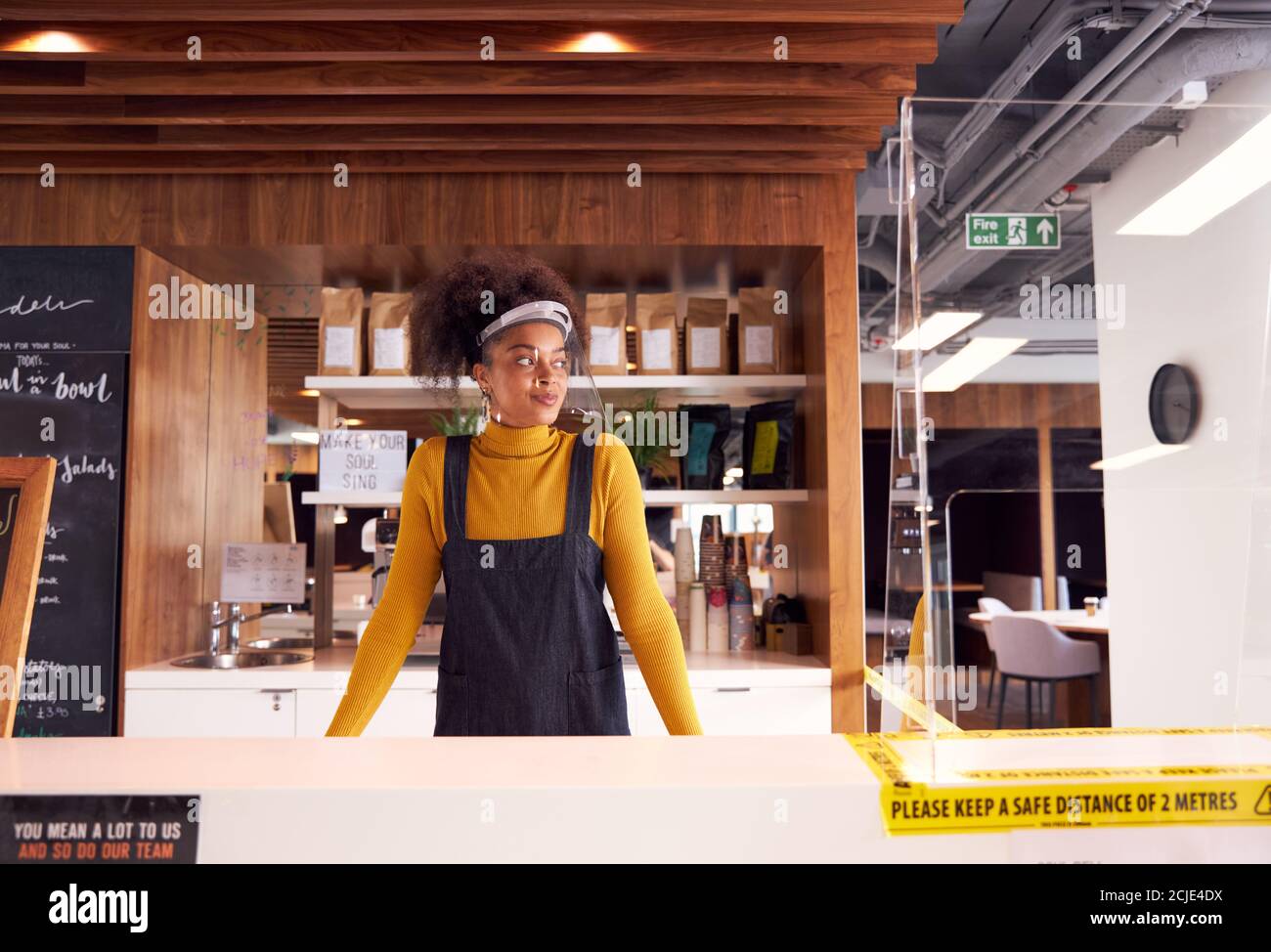 Weibliche Kleinunternehmerin Des Coffee Shops Mit Gesichtsschild Hinter Dem Zähler Während Der Gesundheitsinpandemie Stockfoto