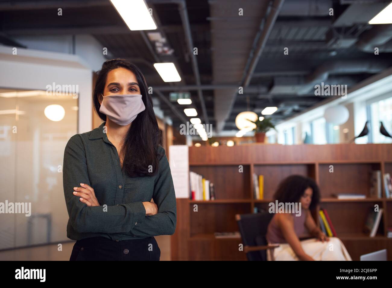 Porträt Der Geschäftsfrau Trägt Gesichtsmaske In Modernen Offenen Plan Büro Während Der Covid-19 Pandemie Stockfoto