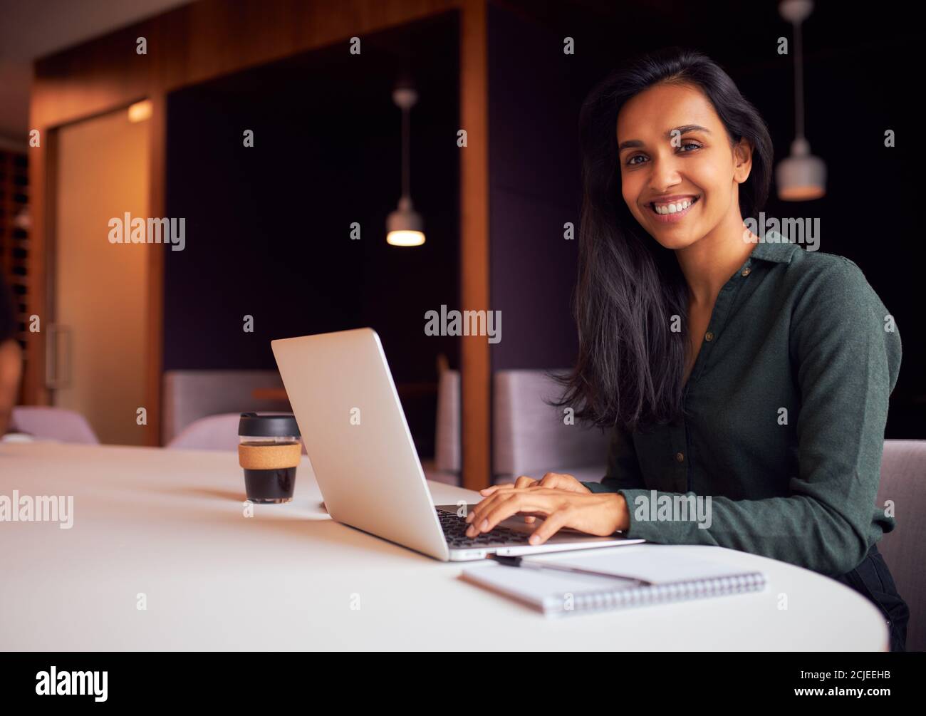 Porträt Der Geschäftsfrau Sitzt Am Meeting-Tisch Arbeiten Auf Laptop Im Modernen Open Plan Office Stockfoto