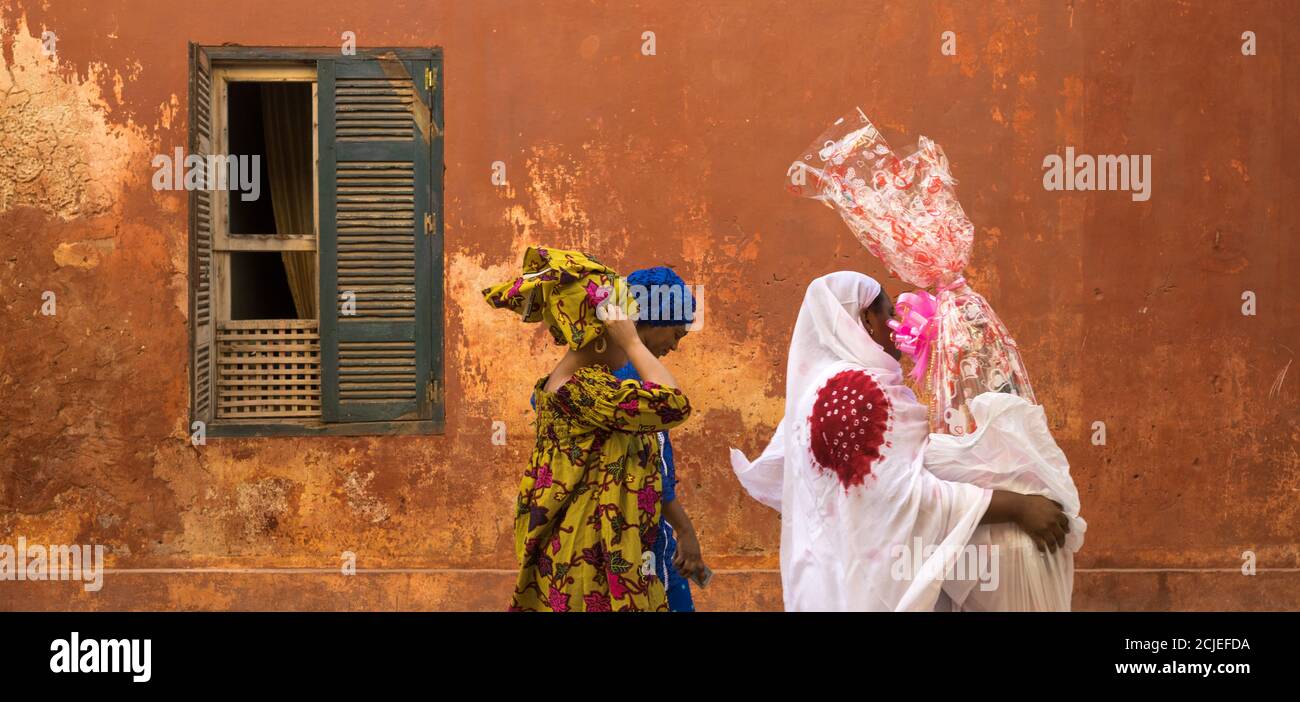 Vorbeifahrende Frauen, Gorée Island, Dakar, Senegal Stockfoto