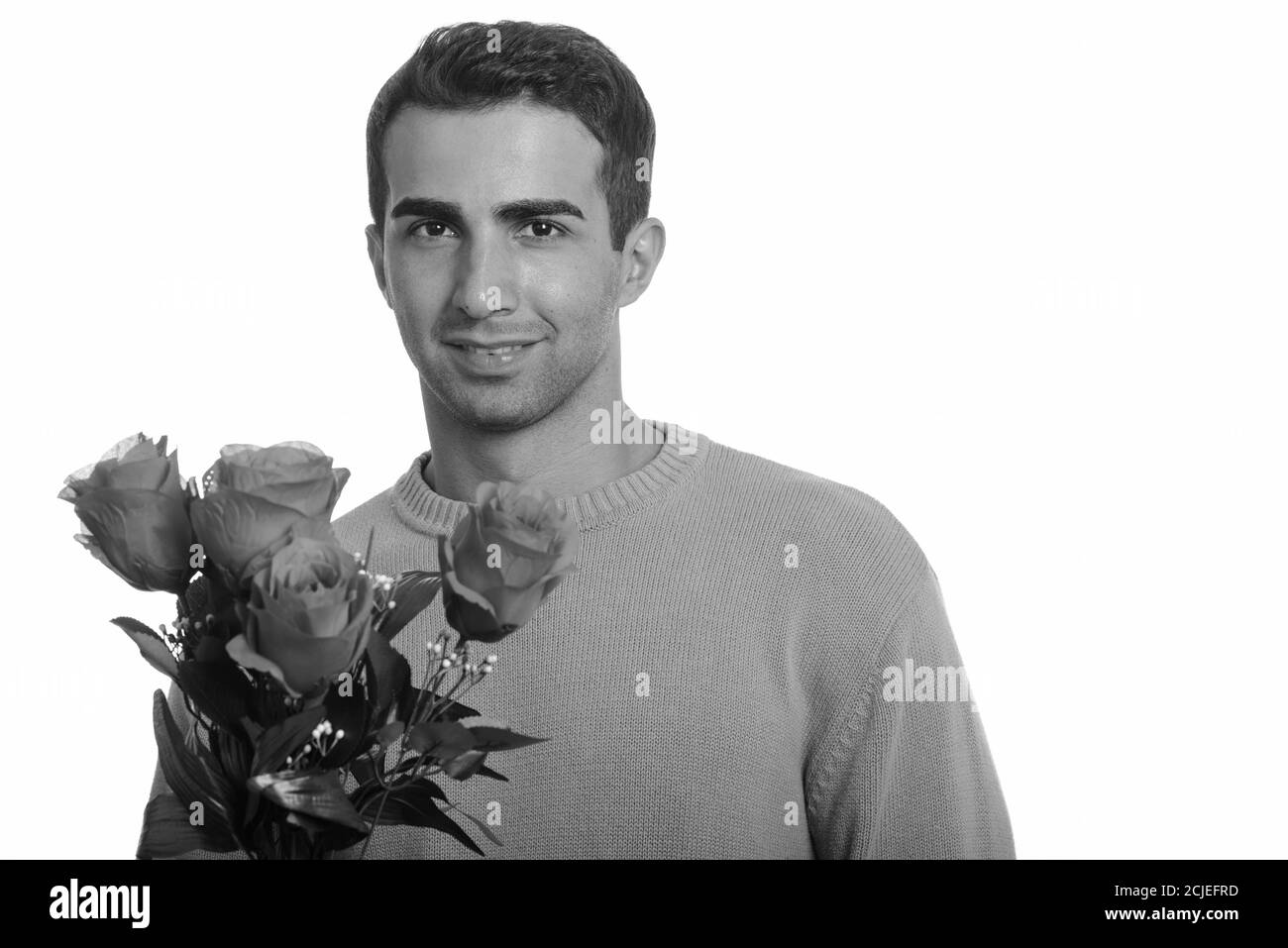 Junger glücklicher iranischer Mann hält rote Rosen bereit für Valentinstag Tag Stockfoto