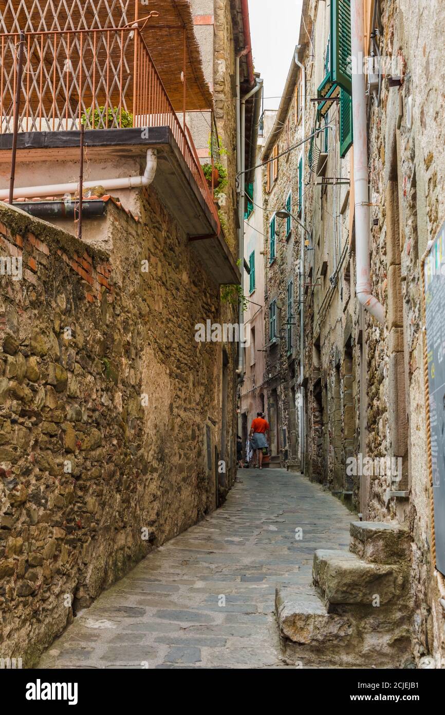 Schöne Aussicht auf eine malerische schmale Straße und Häuser mit alten Fassaden auf jeder Seite im historischen Dorf Corniglia an der Küste von Cinque Terre... Stockfoto
