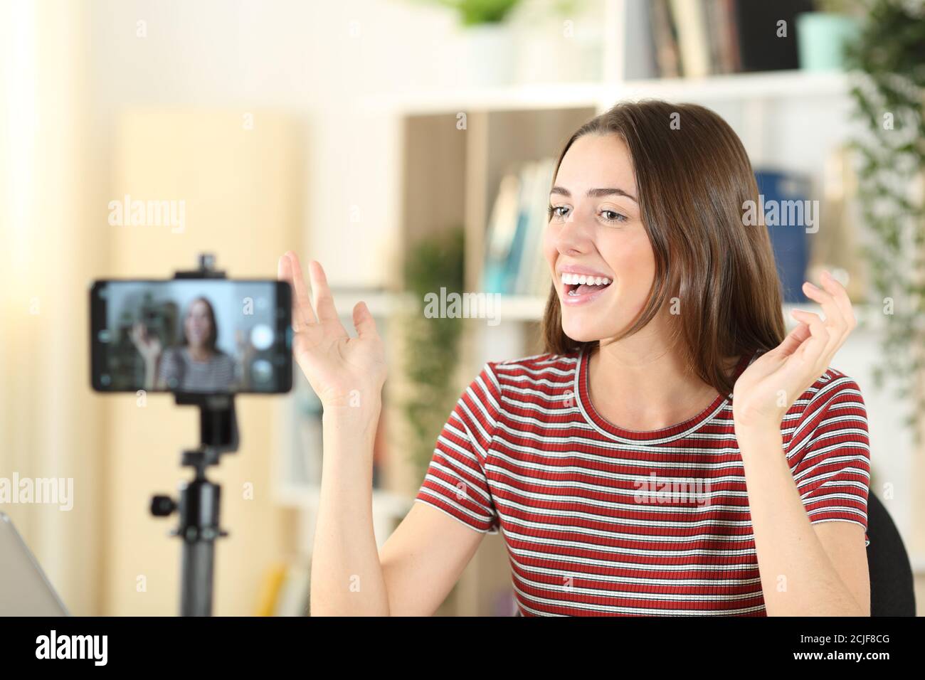 Glücklicher Influencer, der zu Hause mit einem Smartphone Videos aufzeichnet Stockfoto