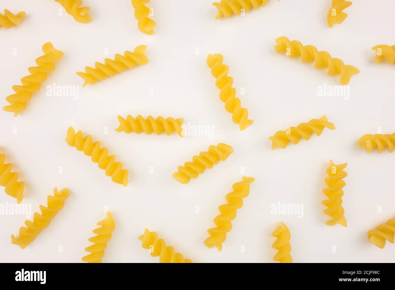 Spiralmuster auf weißem Hintergrund. Italienisches Essen. Nudelzusammensetzung. Flaches Lay-Layout. Stockfoto