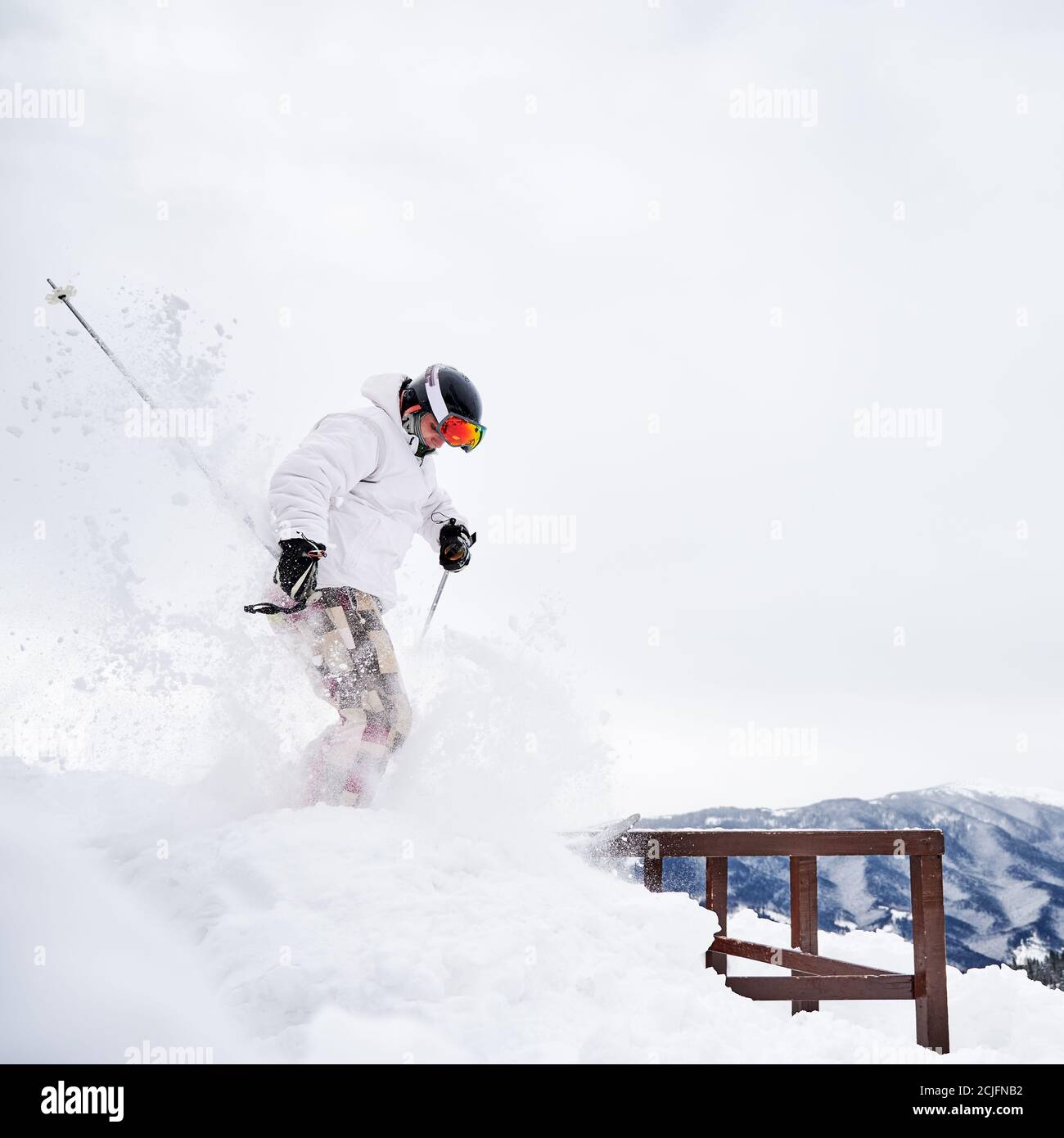 Winter Arten von Sport-Konzept. Skifahrer tragen Wintersport-Kostüm und Skiausrüstung tun Sprungtricks in der Wintersaison. Animation im Skigebiet in den Bergen, Seitenansicht Stockfoto