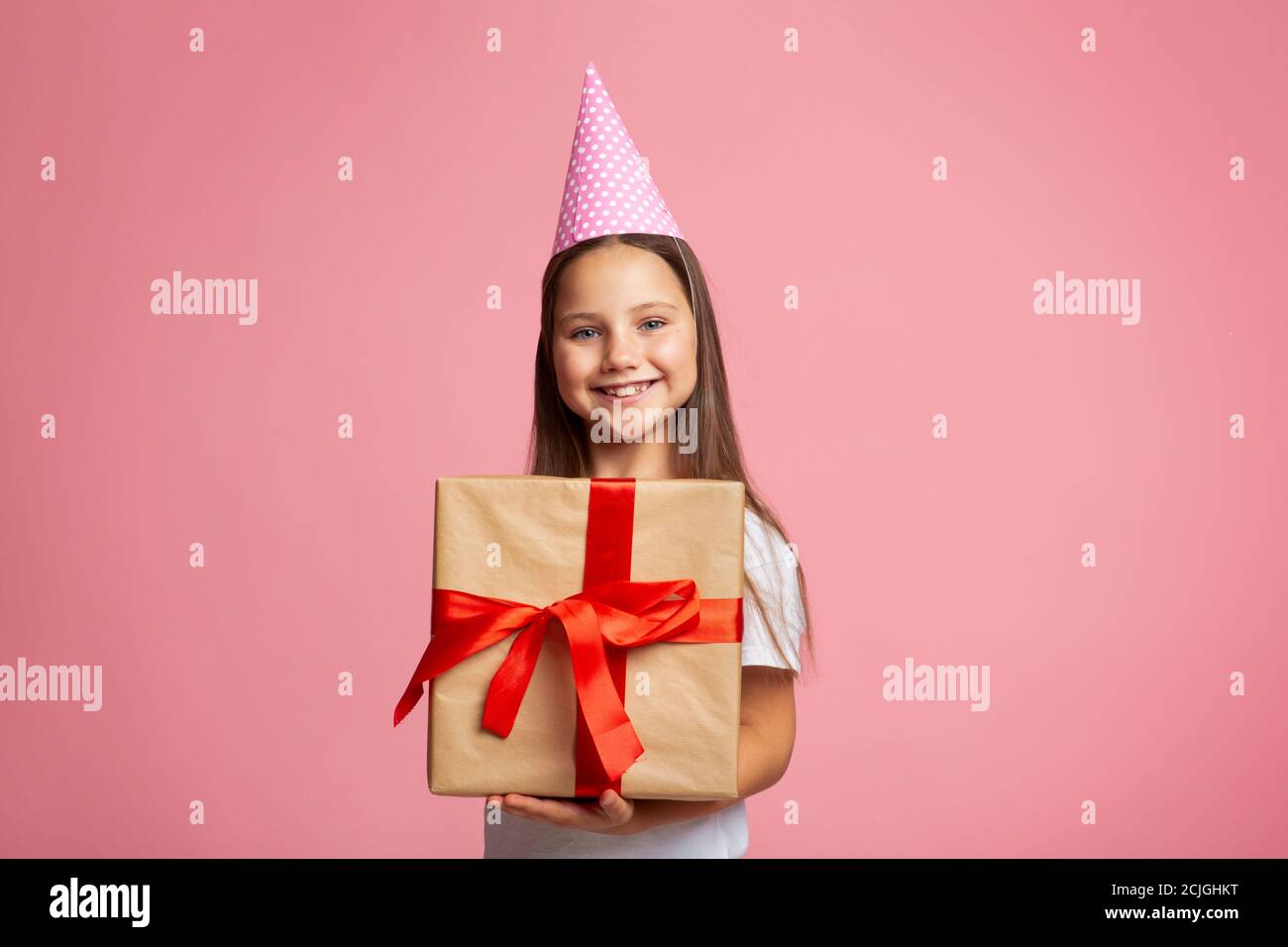 Geburtstagsgeschenk. Portrait aufgeregt Mädchen in Mütze und großes Geschenk Stockfoto