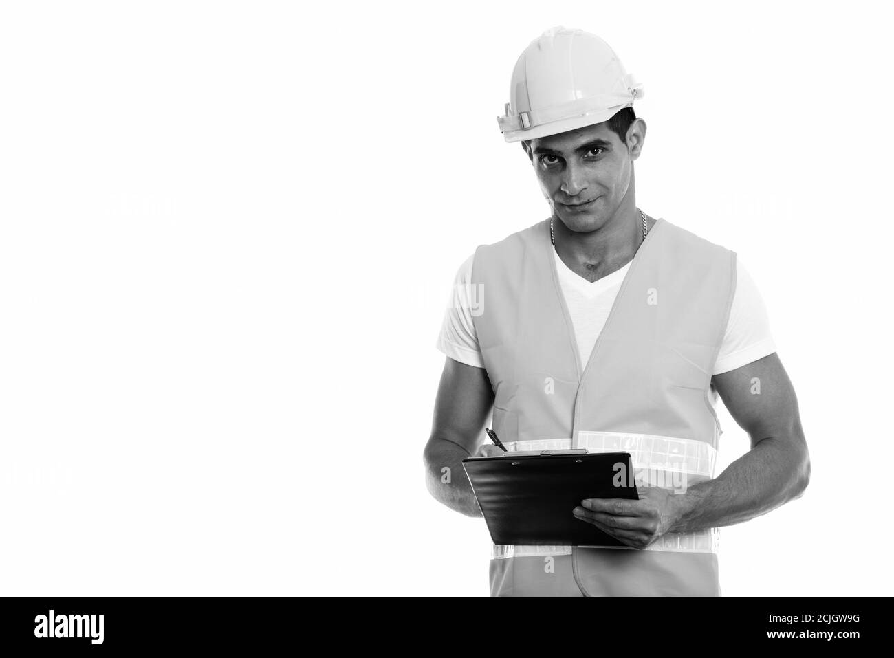 Studio Aufnahme von jungen muskulösen persischen Mann Bauarbeiter schriftlich In der Zwischenablage, während Sie die Kamera betrachten Stockfoto