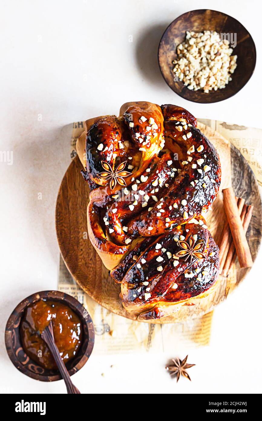 Babka oder Brioche Brot mit Aprikosenmarmelade und Nüssen. Hausgemachtes Gebäck zum Frühstück. Konkreter Hintergrund. Stockfoto