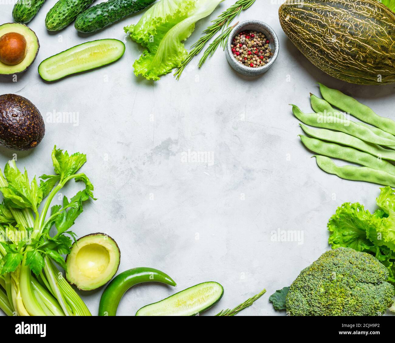 Speiserahmen. Frisches grünes Gemüse auf einem grauen Hintergrund. Gewürz kopieren Stockfoto
