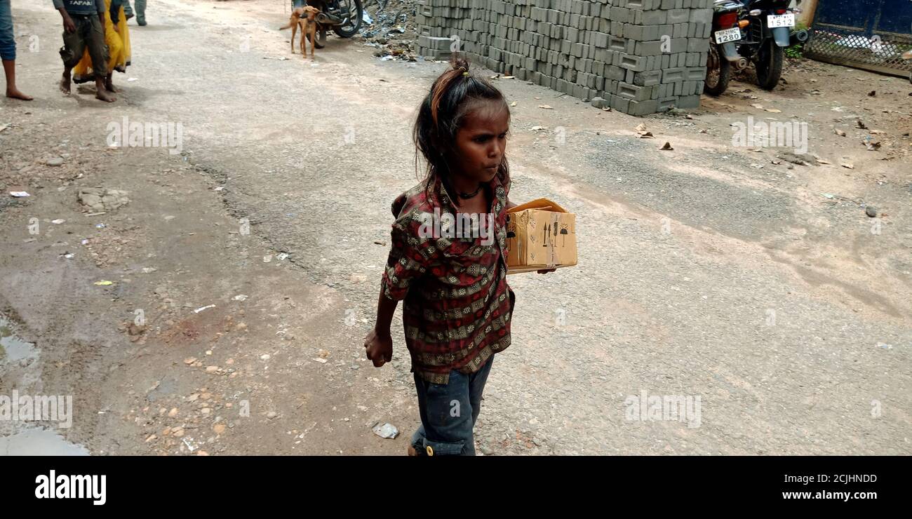 DISTRIKT KATNI, INDIEN - 12. SEPTEMBER 2019: Ein indisches Dorf arme Bettlerin geht auf die Straße hält Lebensmittel-Box auf der Hand. Stockfoto
