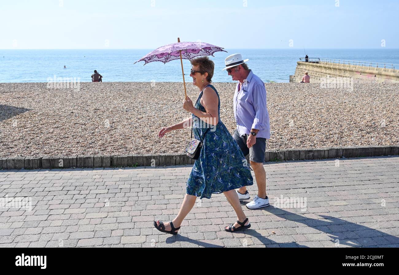 Brighton UK 15. September 2020 - Diese Dame bleibt im Schatten am Brighton Strand, da sie das Beste aus einem weiteren heißen Tag am Meer machen, da die Temperaturen in einigen Teilen des Südostens wieder 30 Grad erreichen werden: Kredit Simon Dack / Alamy Live Nachrichten Stockfoto
