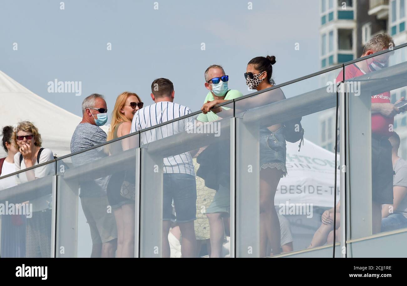 Brighton UK 15. September 2020 - Besucher mit Gesichtsbezügen an der Küste von Brighton können einen weiteren heißen Tag am Meer nutzen, da die Temperaturen in einigen Teilen des Südostens wieder auf 30 Grad steigen werden : Credit Simon Dack / Alamy Live News Stockfoto