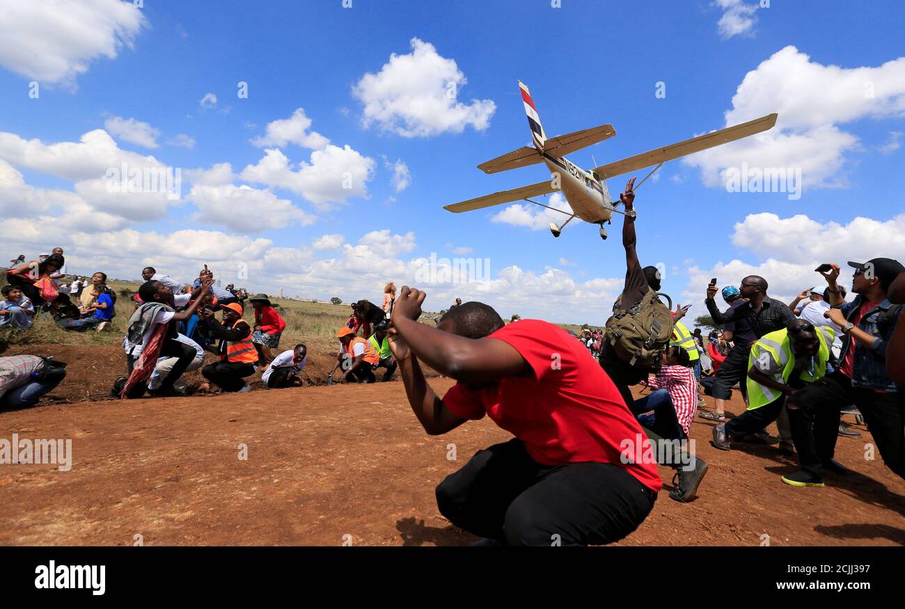 Zuschauer zu reagieren wie ein Flugzeug über sie während der Vintage-Luft-Rallye im Nairobi-Nationalpark in Kenias Hauptstadt Nairobi, 27. November 2016 fliegt. REUTERS/Thomas Mukoya TPX Bilder des Tages Stockfoto