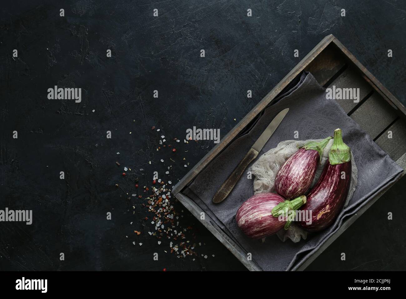Aubergin-Sorten in schwarzer Schüssel über dunklem Schieferhintergrund Stockfoto