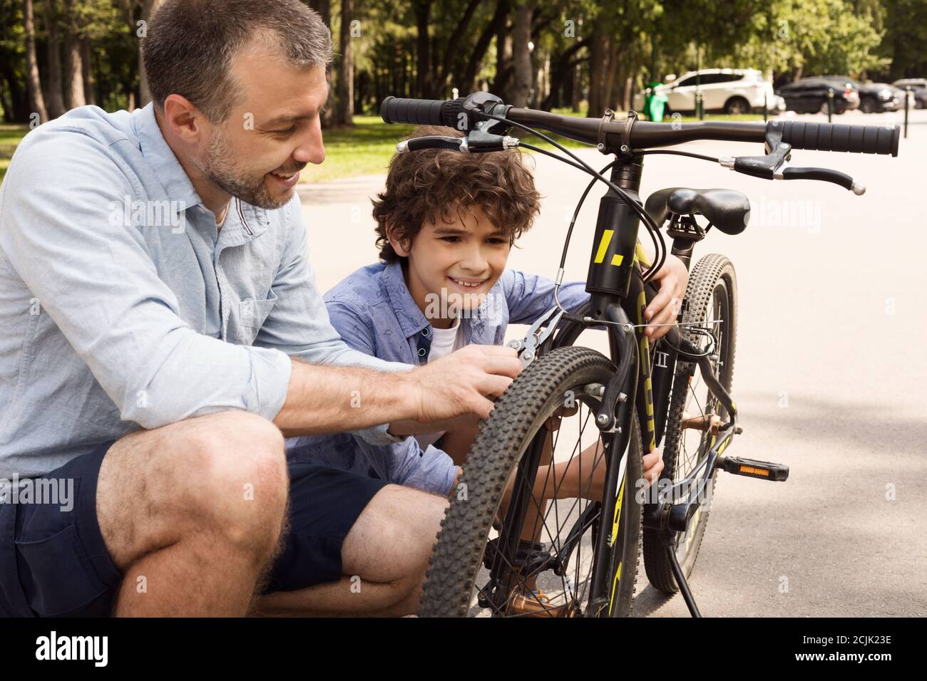 Nahaufnahme Porträt von fröhlichen Vater und Sohn Befestigung Fahrrad Stockfoto