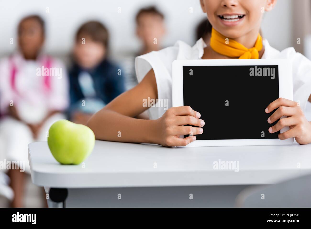 Beschnittene Ansicht von Schulmädchen halten digitale Tablette mit leerem Bildschirm An der Rezeption in der Nähe von Apple Stockfoto