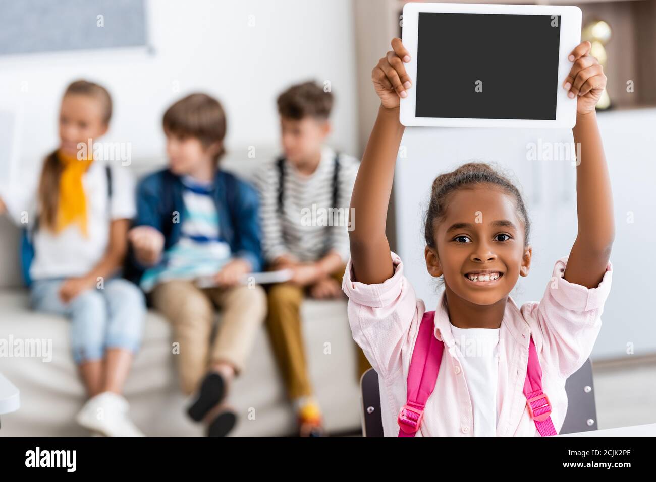 Selektive Fokus der afroamerikanischen Schulmädchen halten digitale Tablette mit Leerer Bildschirm im Klassenzimmer Stockfoto