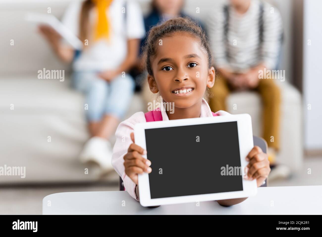 Selektive Fokus der afroamerikanischen Schulmädchen zeigt digitale Tablette mit Leerer Bildschirm am Schreibtisch Stockfoto