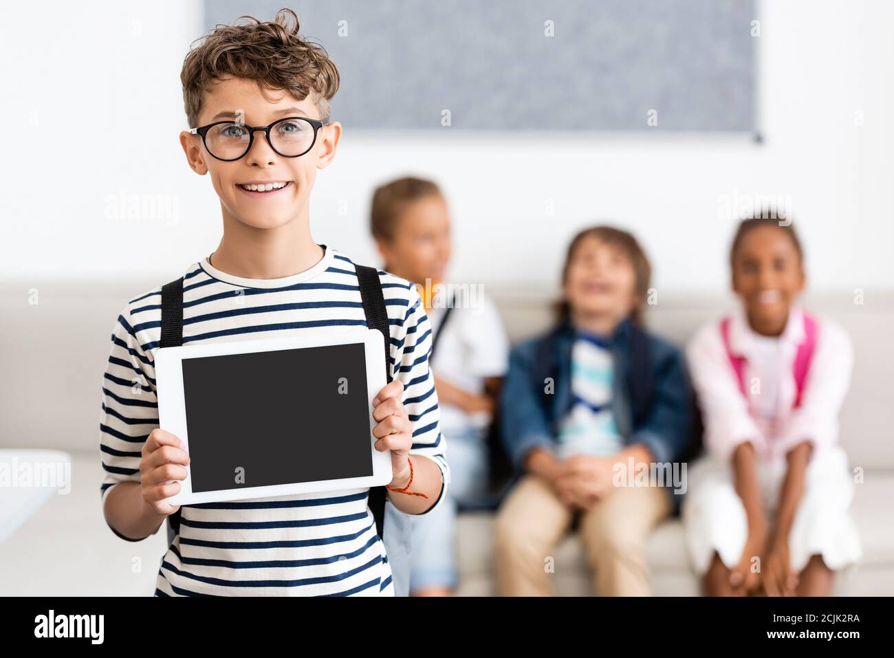 Selektive Fokus der Schüler in Brillen zeigen digitale Tablet mit Leerer Bildschirm im Klassenzimmer Stockfoto