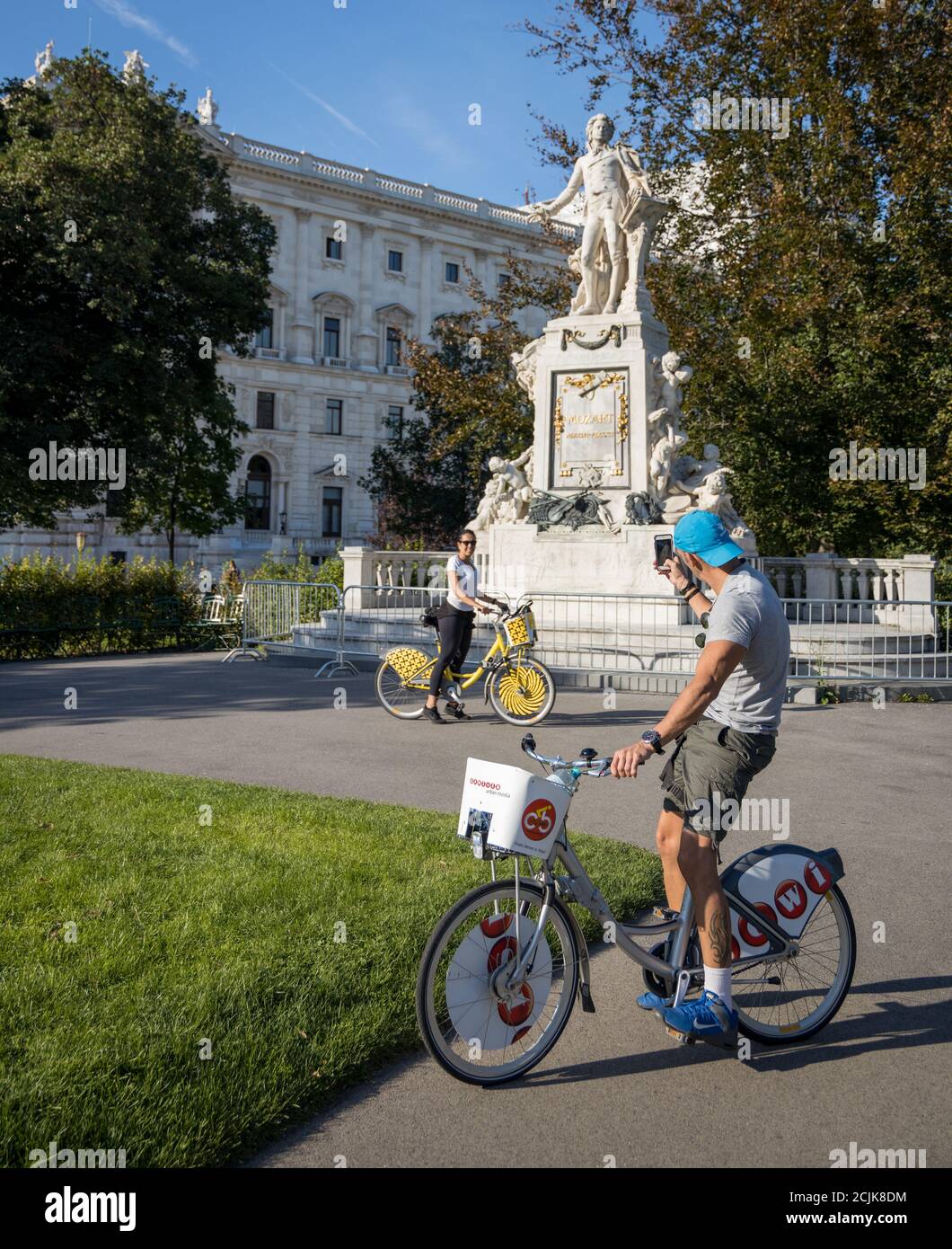 Touristen fotografieren sich vor einer Mozart-Statue in Burggarten, Wien, Österreich Stockfoto