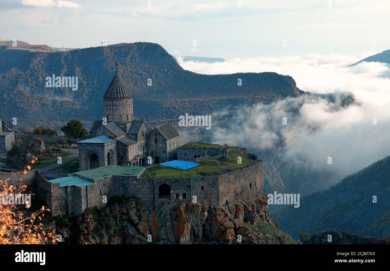 Morgenbild des Armenischen Apostolischen Klosters Tatev aus dem 9. Jahrhundert in Armenien und dem nahegelegenen Tal voller Wolken. Stockfoto