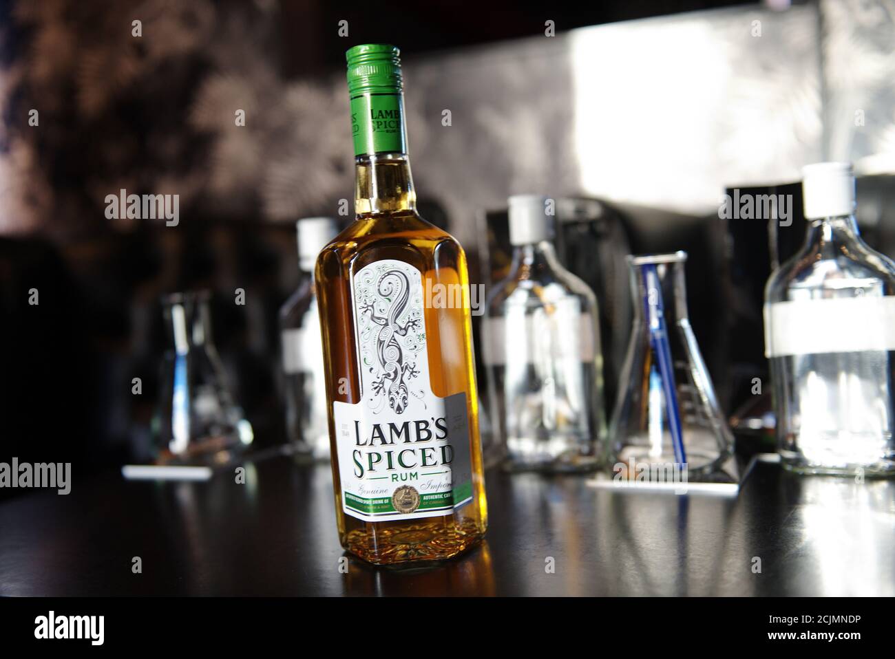 Lamb's Spiced Rum Flasche an der Bar in einem trendigen Lokal. Dahinter sind noch einige andere Flaschen und Cocktail-Mischgeräte. Lämmer ist eine Mischung aus 18 enahnced ru Stockfoto