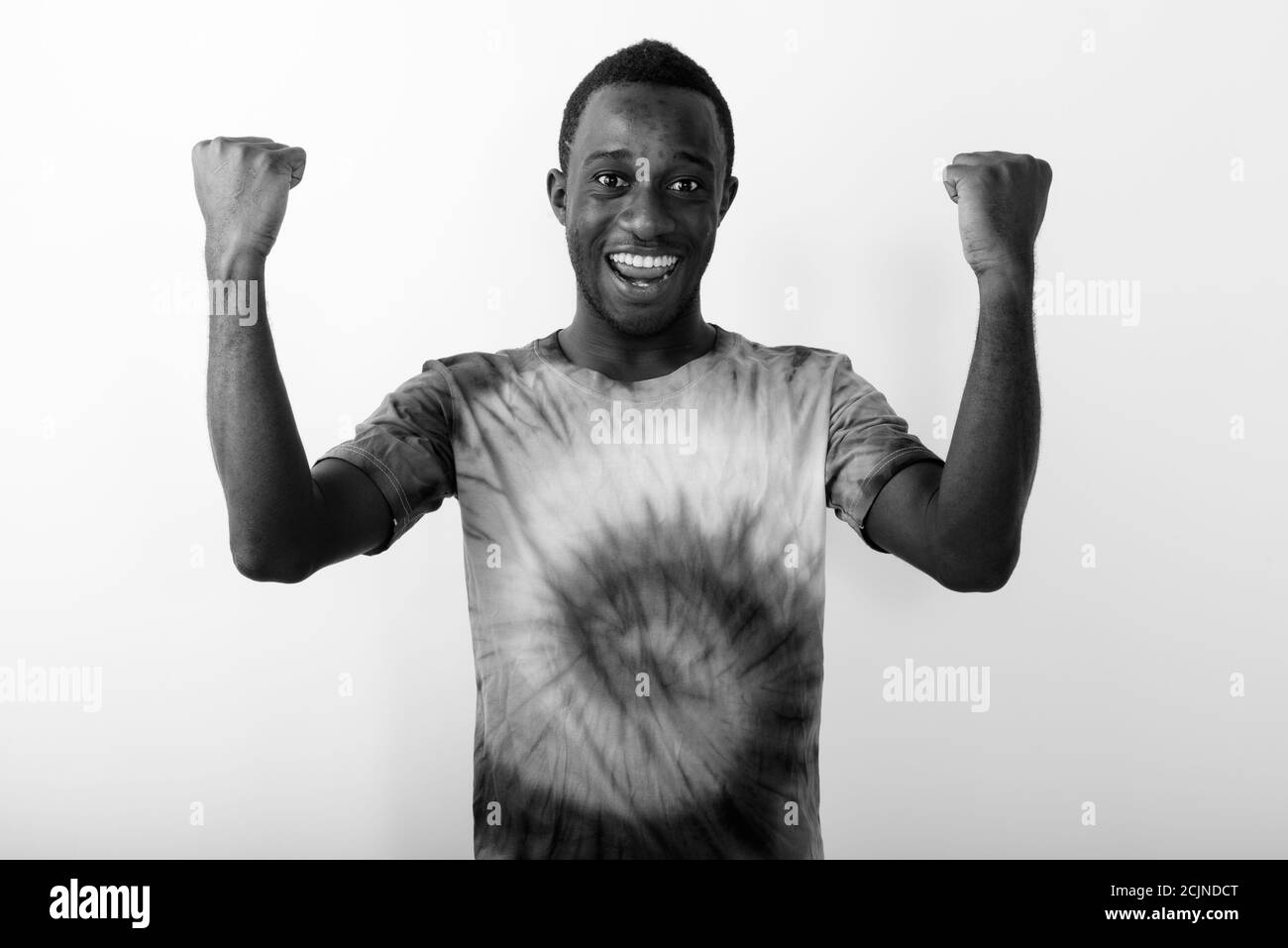 Studio-Aufnahme von jungen schwarzen afrikanischen Mann gegen lächeln mit Arme vor weißem Hintergrund angehoben Stockfoto