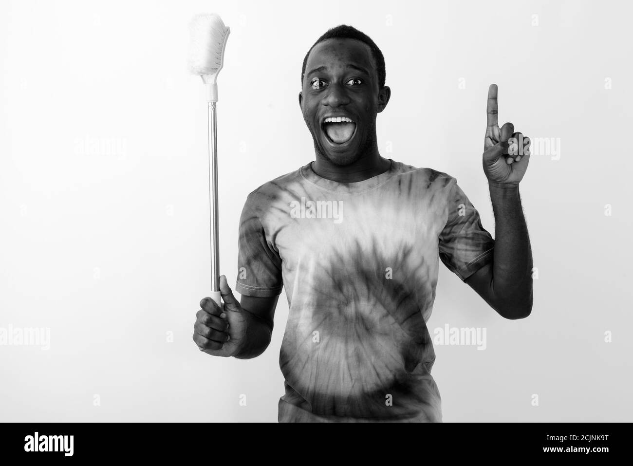 Junger afrikanischer Mann, der aufgeregt und glücklich beim Putzen ist Pinsel und Zeigefinger nach oben Stockfoto
