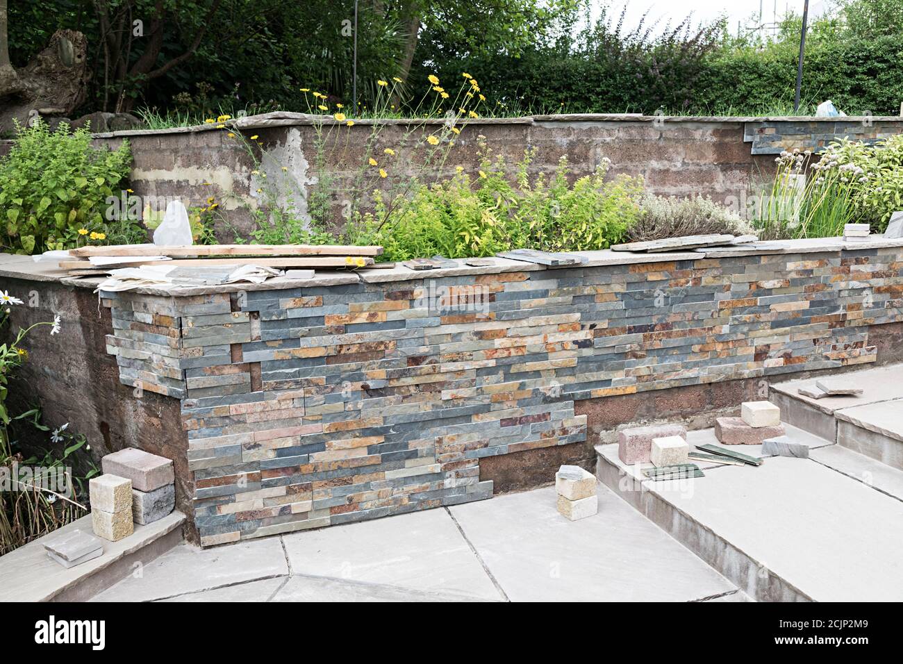 Steinverkleidungen werden an der Gartenrückwand installiert, Großbritannien Stockfoto