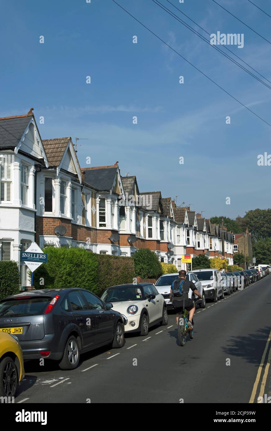 Straße von viktorianischen Reihenhäusern mit Erkerfenstern in twickenham, middlesex, england, mit vorbeifahrenden Radfahrer Stockfoto