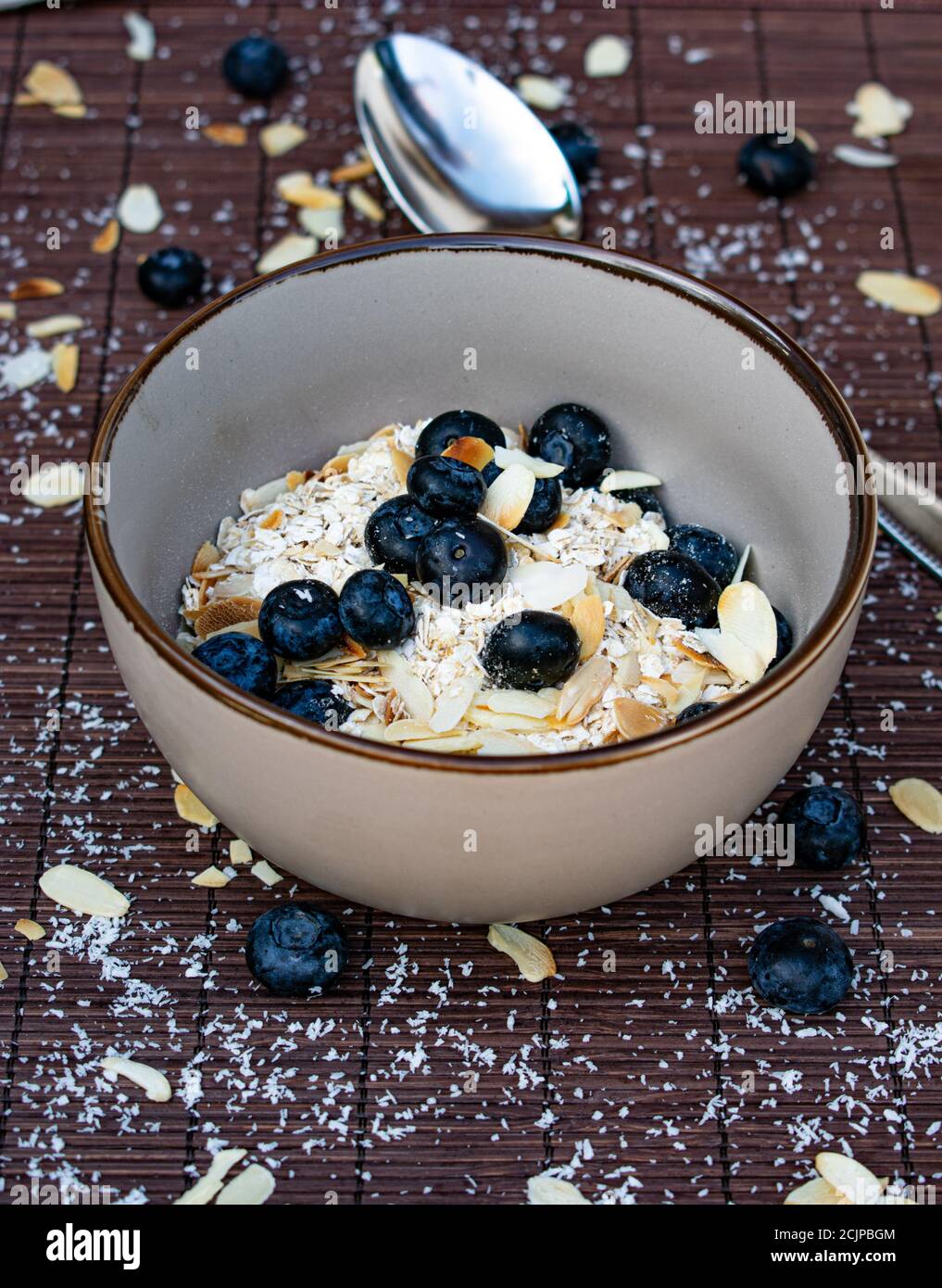 Haferflocken Müsli mit Beeren und Nüssen ohne Milch in einem Schüssel Stockfoto