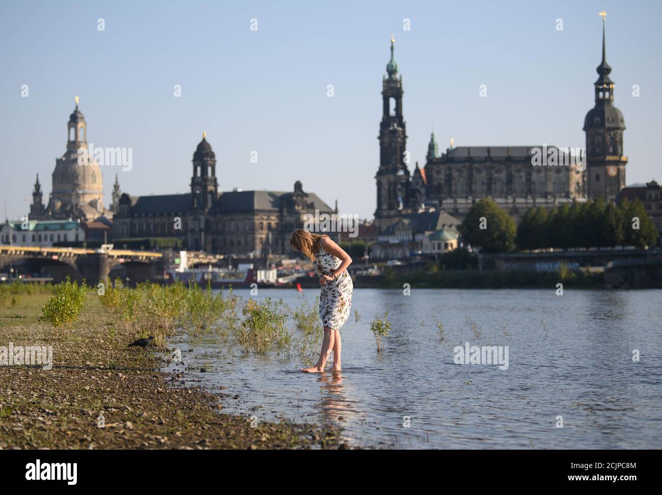 Dresden, Deutschland. September 2020. Am Nachmittag steht eine Frau mit ihren Füßen in der Elbe vor der Altstadtkulisse mit der Frauenkirche (l-r), dem Ständehaus, der Hofkirche und dem Hausmannsturm. Quelle: Robert Michael/dpa-Zentralbild/ZB/dpa/Alamy Live News Stockfoto