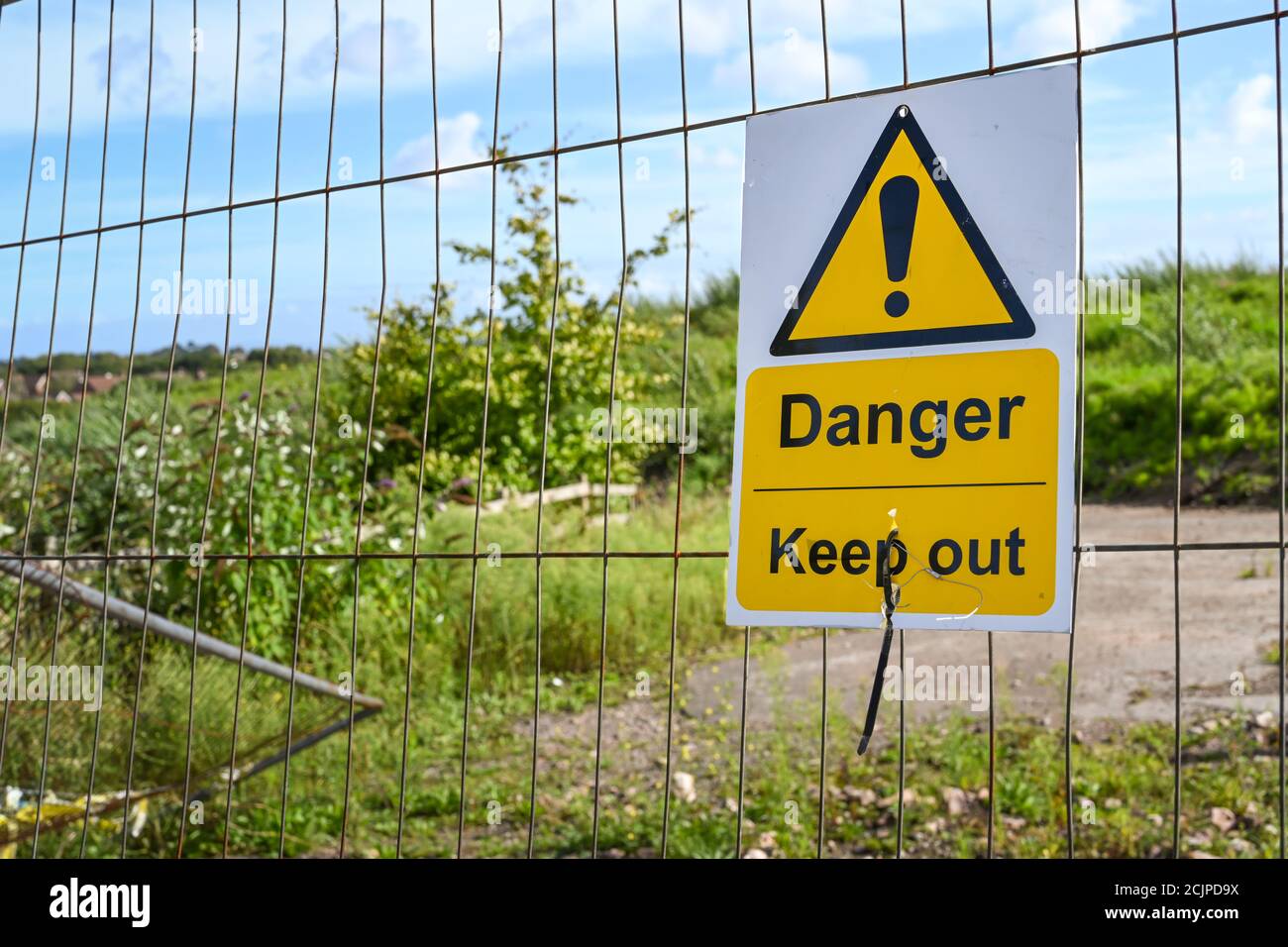 „Danger Keep Out“-Schild auf Metallzäunen, die den Zugang zu blockieren Eine Entwicklungsstelle Stockfoto