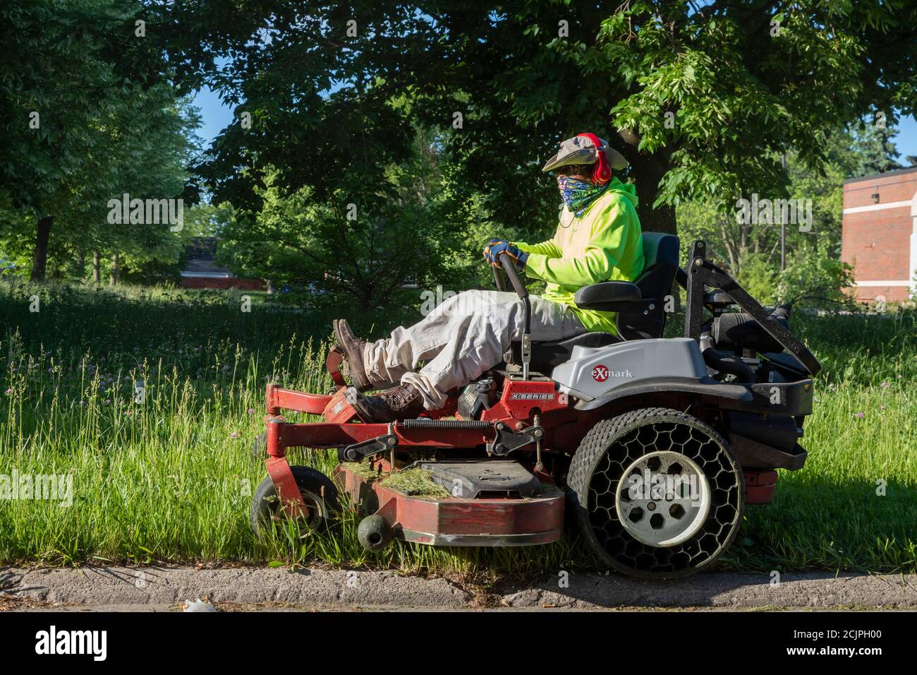 Detroit, Michigan - Arbeiter der Detroit Grounds Crew schneiden das Gras auf dem Gelände der Burbank School, einer von Dutzenden von geschlossenen öffentlichen Schulen i Stockfoto