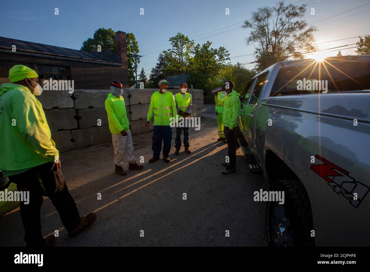 Detroit, Michigan - Arbeiter der Detroit Grounds Crew treffen sich im Morgengrauen, bevor sie auf dem Gelände geschlossener öffentlicher Schulen das Gras schneiden. Stockfoto