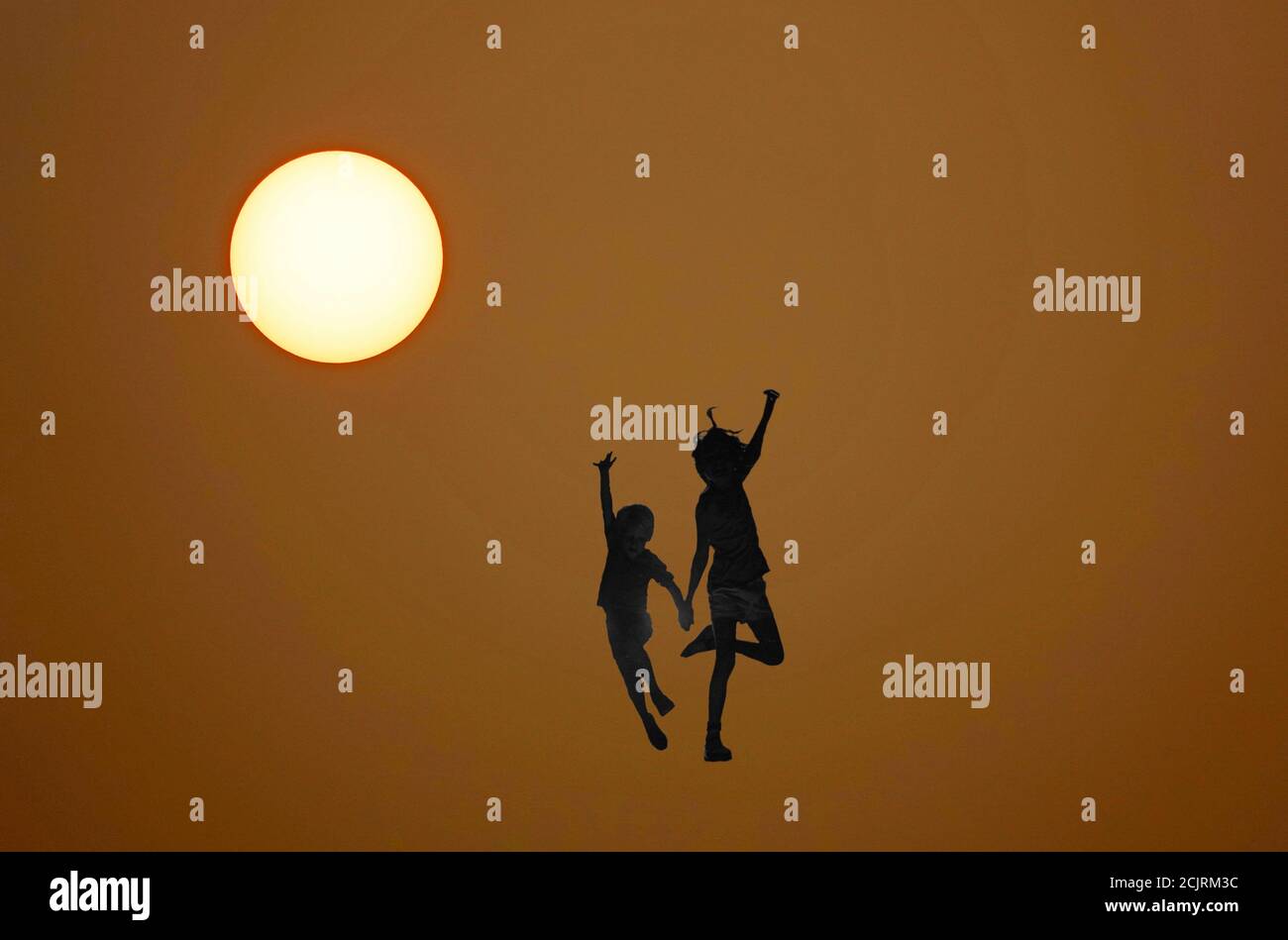 Silhouette eines Bruders und einer Schwester, die unter der Sonne tanzen. Stockfoto