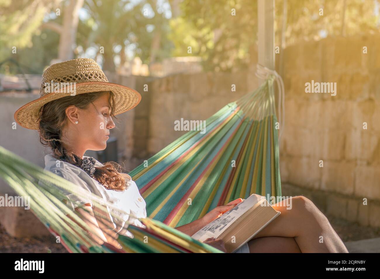 Ruhige Szene von einem jungen cacucasian Mädchen Lesung in ein Hängematte Stockfoto
