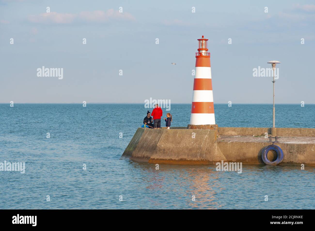 Rot-weißer Leuchtturm in Nida, Litauen mit Menschen Stockfoto