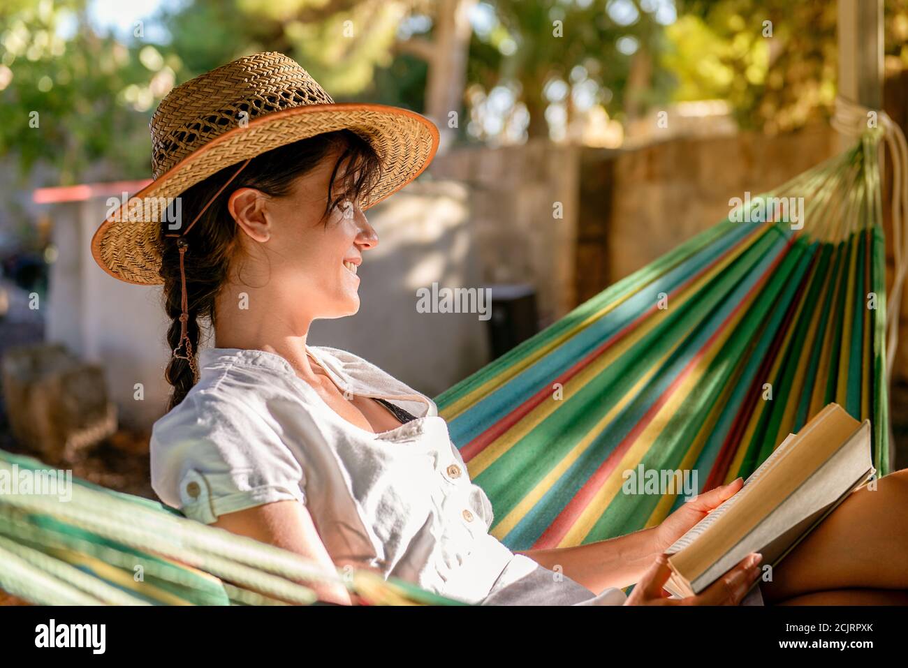 Ruhige Szene von einem jungen cacucasian Mädchen Lesung in ein Hängematte Stockfoto