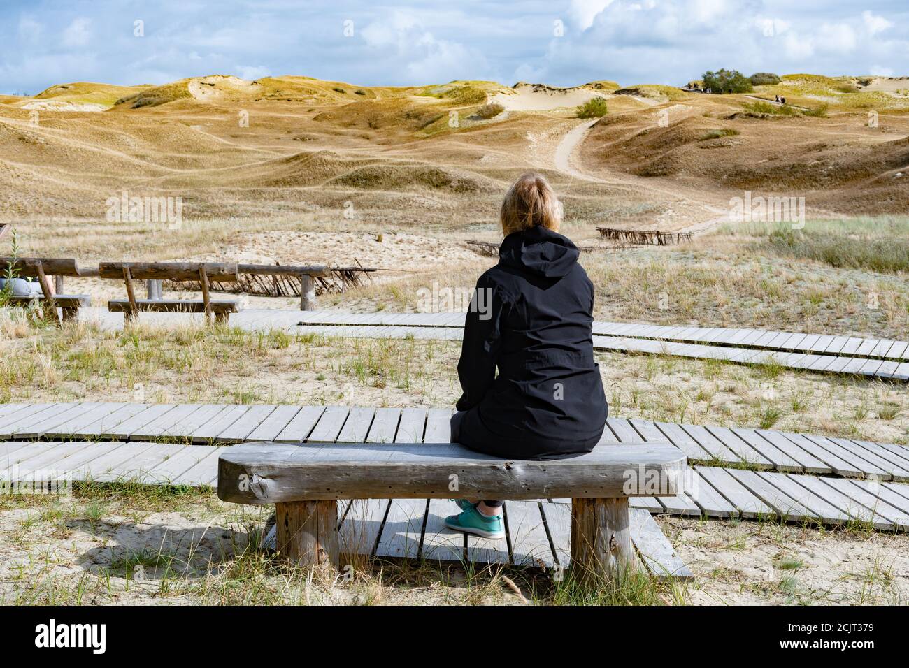 Blonde weibliche Haare auf der Holzbank Blick auf Nagliai Naturschutzgebiet in Neringa, Litauen. Abgestorbene Dünen, Sandhügel von starken Winden gebaut, mit rav Stockfoto