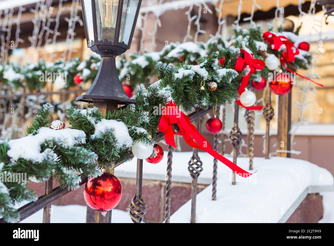 Weihnachten Stadtbild - Dekoration Geländer Veranda am Vorabend des Urlaubs. Weihnachtskugeln und Bänder. Winterurlaub. Stockfoto