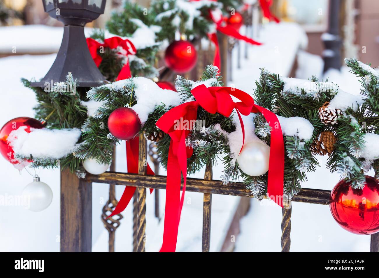 Weihnachten Stadtbild - Dekoration Geländer Veranda am Vorabend des Urlaubs. Weihnachtskugeln und Bänder. Winterurlaub. Stockfoto