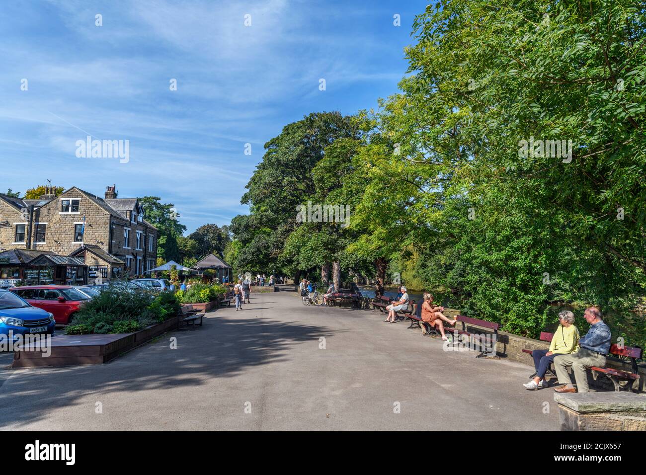 Menschen, die vor dem Riverside Hotel am Anfang des Dales Way, Ilkley, North Yorkshire, England, Großbritannien, sitzen. Stockfoto