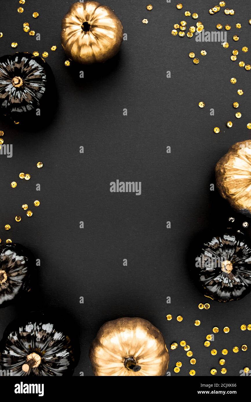 Moderner Hintergrund mit schwarzem und goldenem Halloween Kürbis mit Platz für Text. Isoliert auf schwarzem Hintergrund. Flach liegend, Draufsicht. Stockfoto