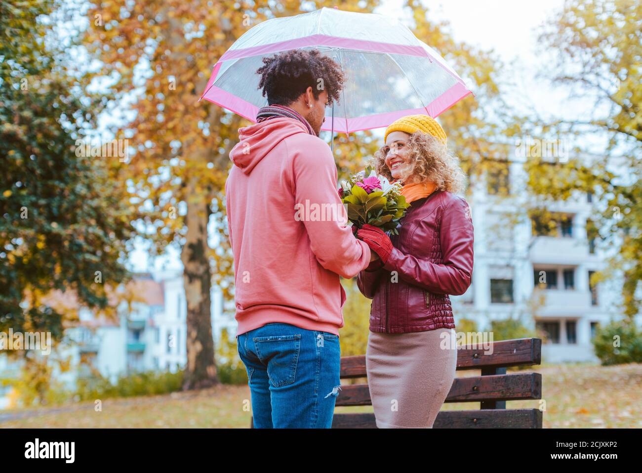 Schwarzer Mann Blumen zu seinen Kaukasischen Freundin im Herbst Stockfoto