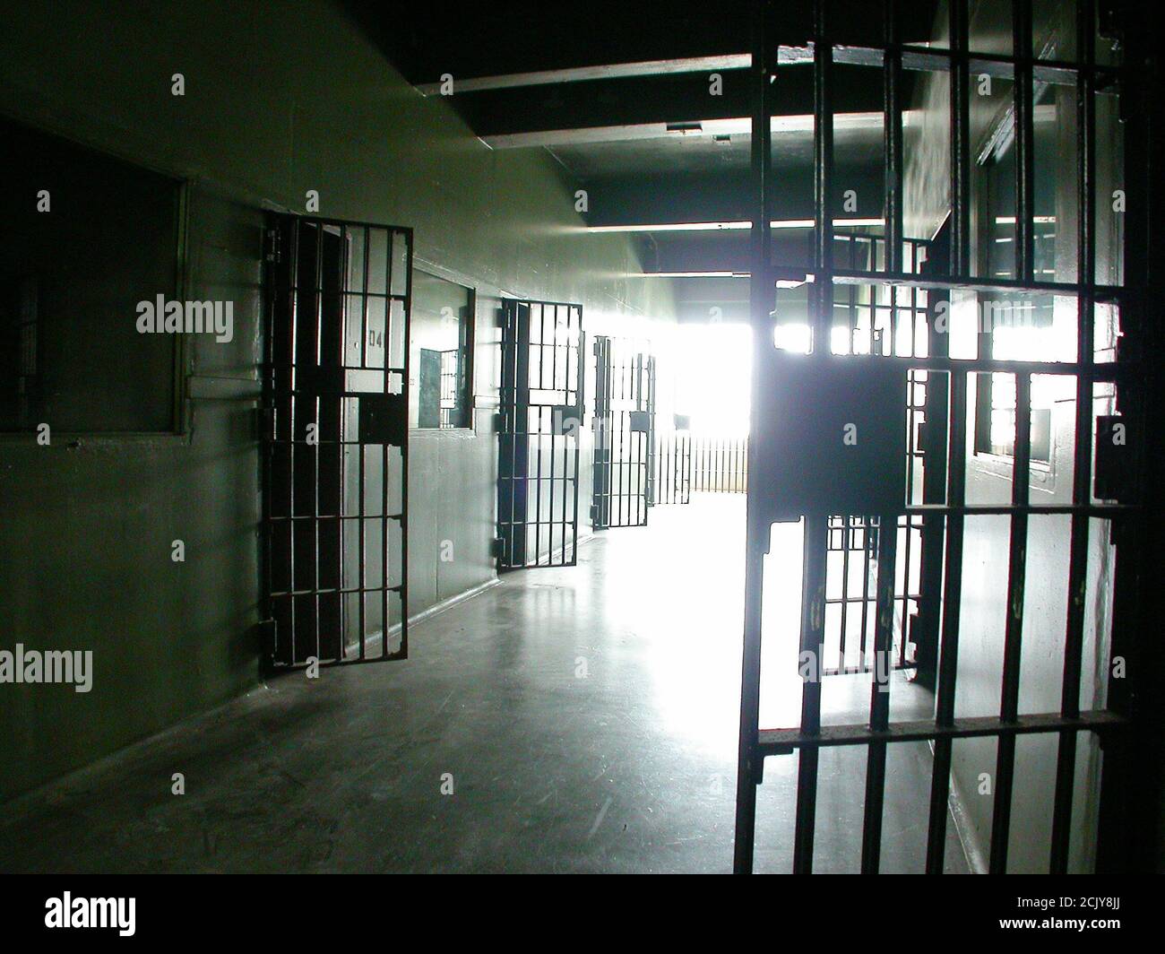 Blick in einen geschlossenen Gefängniszellenblock in einer ungenutzten heruntergekommenen staatlichen Einrichtung. Stockfoto