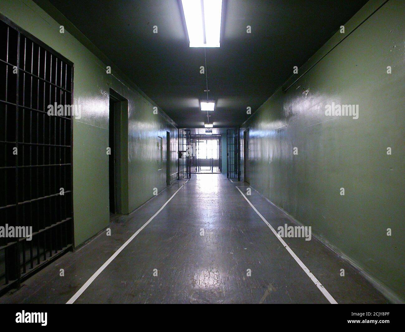 Heruntergekommener Gefängniszellkorridor in einer nicht genutzten staatlichen Einrichtung. Stockfoto