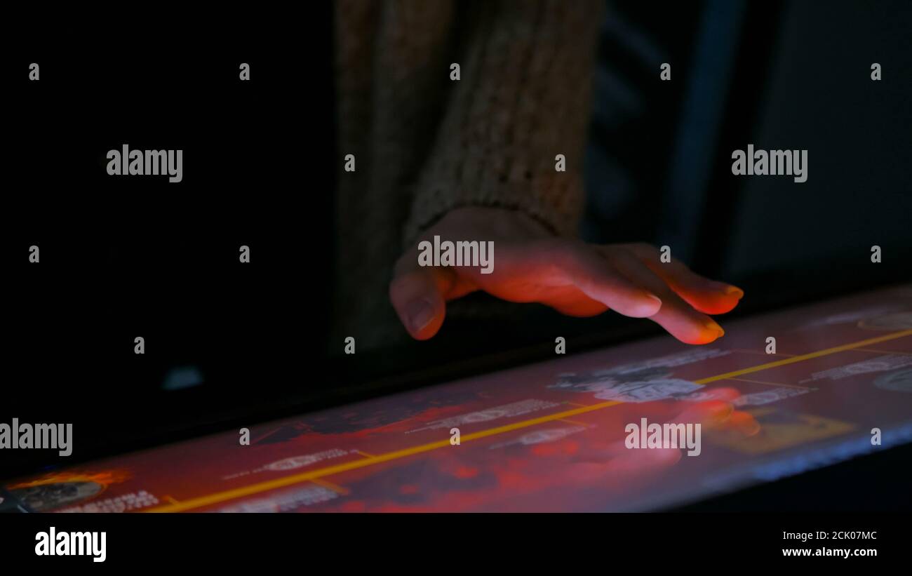 Frau mit interaktiven Touchscreen Display in der modernen historischen Museum. Am Abend Zeit, Lowlight. Bildung und Unterhaltung Konzept. Nahaufnahme Stockfoto