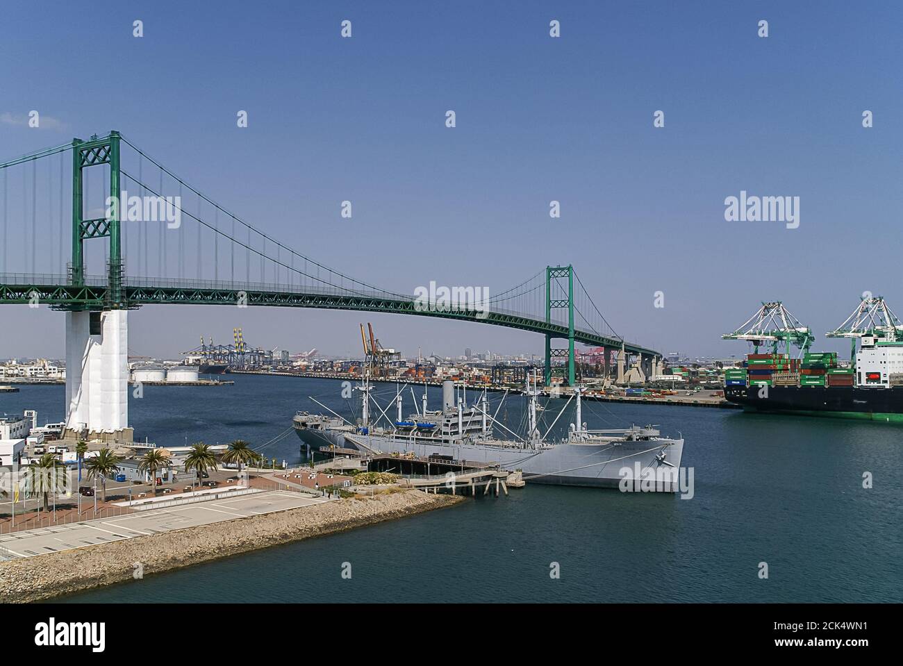 Los Angeles, USA - 20. April 2008: Hafen von San Pedro. Grüne Suspension Vincent Thomas Brücke unter blauem Himmel über Wasser Weg mit Container Yards und shi Stockfoto